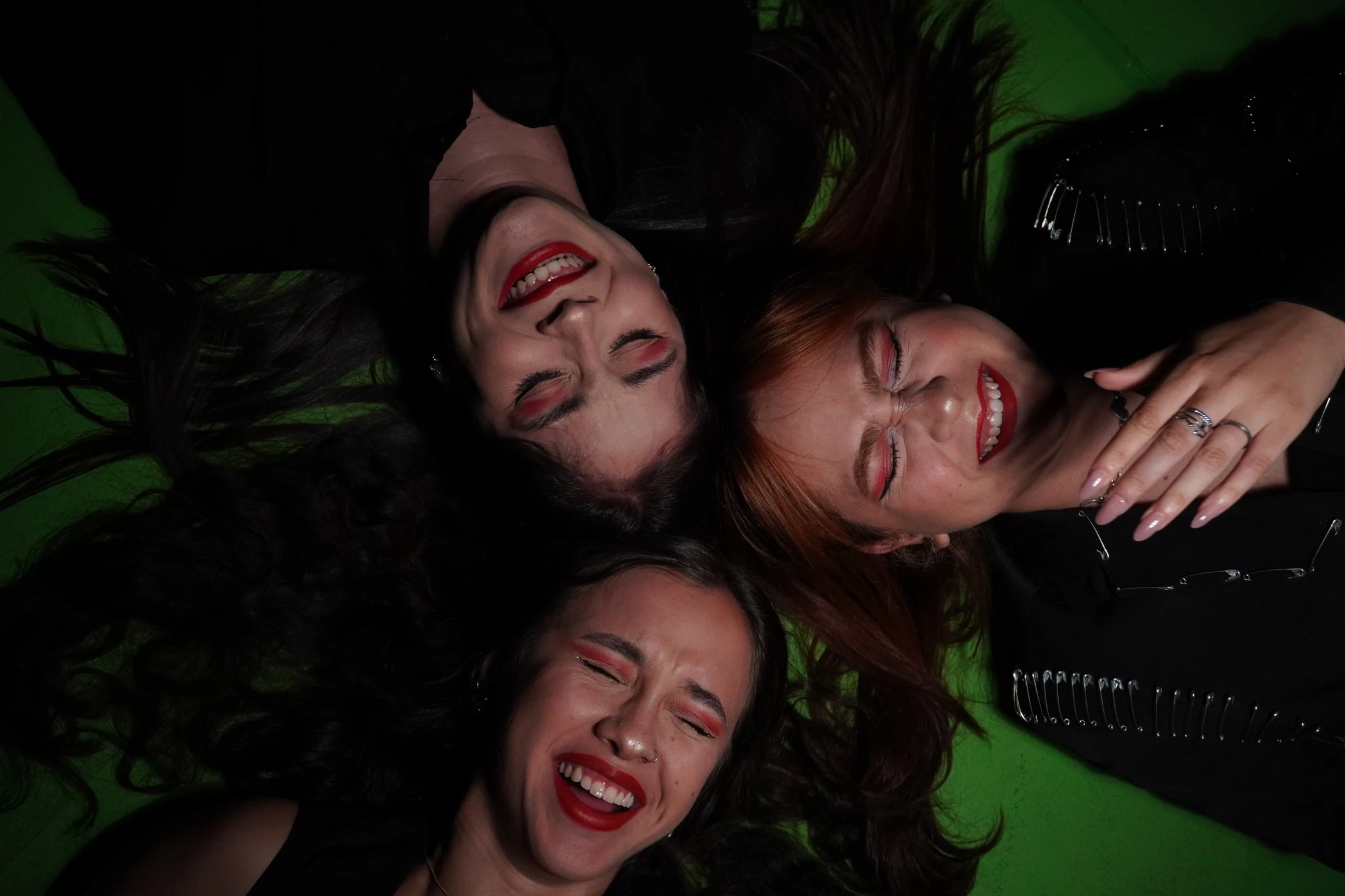 Fotografia original das três personagens em composição vista de cima e cenário verde