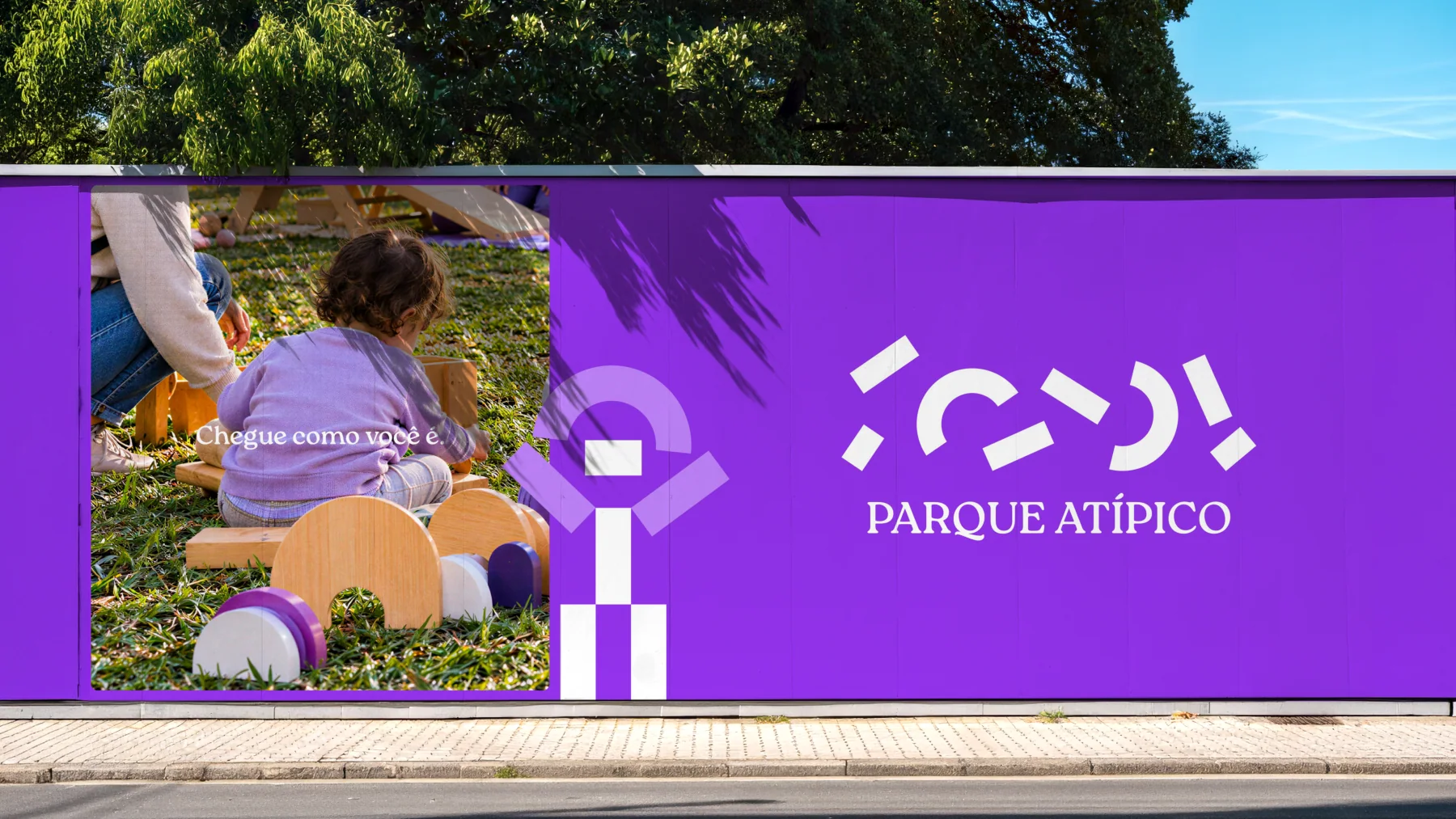Painel roxo do Parque Atípico com assinatura e fotografia em contexto de parque